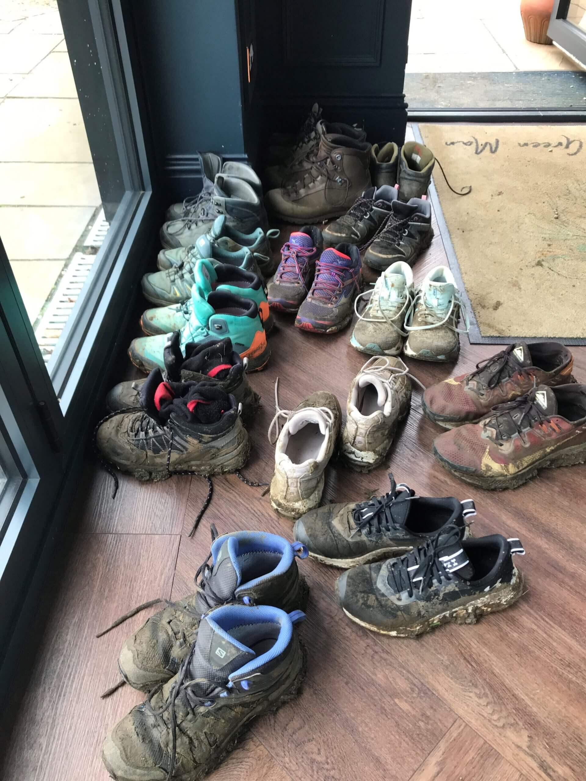 A collection of muddy boots on the floor
