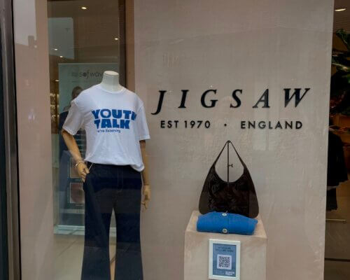 A picture of a Youth Talk T shirt in the window of Jigsaw store in St Albans