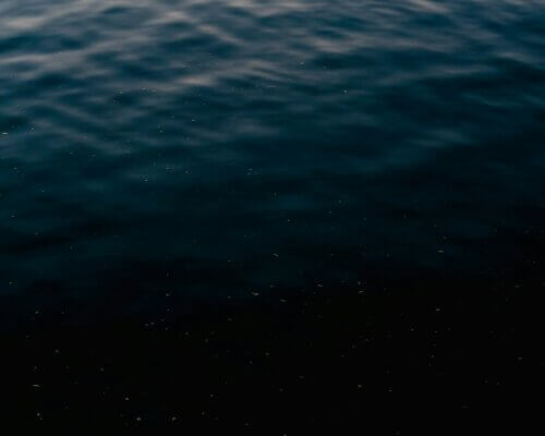 A picture of still water with the reflection of the sun