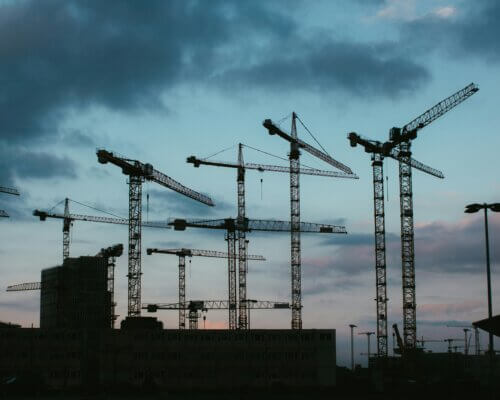 A picture of a skyline at sunset with construction building works in view