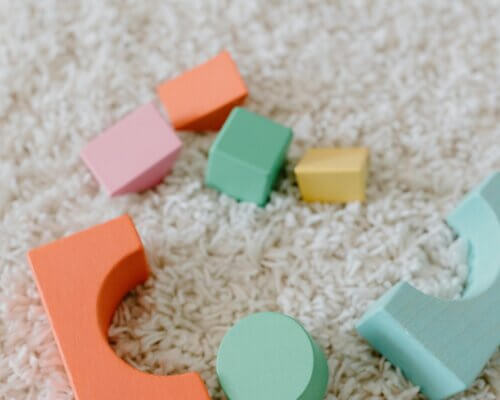 Picture of colourful baby toys sprawled out on a cream carpet