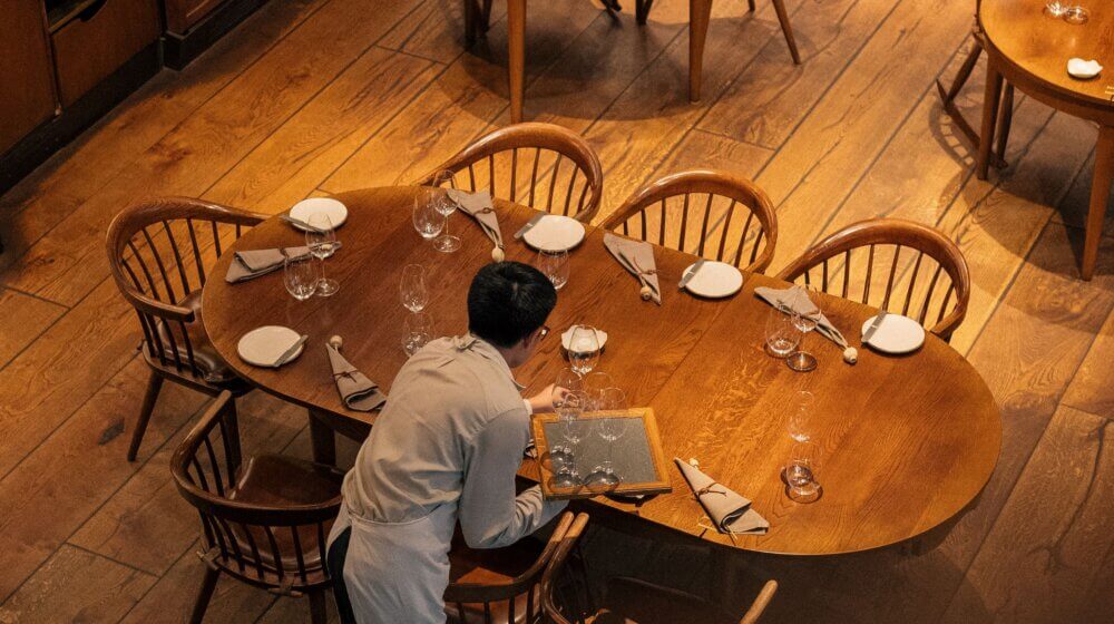 waiter laying table in restaurant
